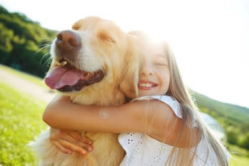 Mädchen umarmt glücklich den Hund