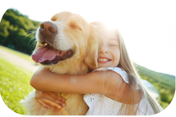 Mädchen umarmt glücklich einen Hund